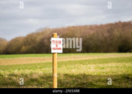 Flacher Fokus eines Private No Footpath Schild am Rande der neuen Kulturen auf einem Feld gepflanzt gesehen. Stockfoto