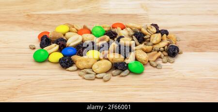 Süßes und salziges Trail-Mix auf einem Holzschneidebrett Seitenansicht. Stockfoto