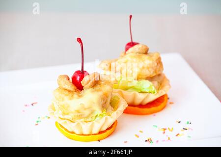 Torten mit frischen Kirschen und Vanillepudding und Karamell, leckeres Dessert auf einem Holztisch, Nahaufnahme Stockfoto