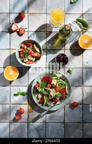 Mediterrane Gerichte am Kacheltisch: Gemüse- und Obstsalat, Zitronen- und Minzlimonade Stockfoto