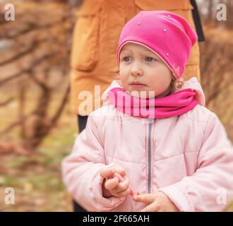 Porträt eines Mädchens. Kleines Mädchen in warmen Kleidern auf der Straße. Stockfoto