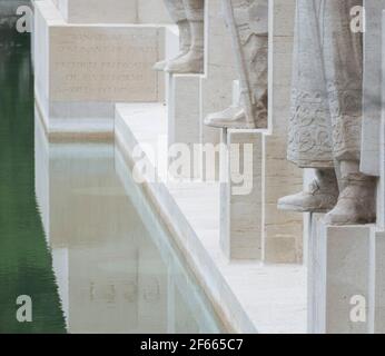 Ein Detail der Reformationsmauer, Parc des Bastions, Genf, Schweiz, zeigt die Füße mehrerer Statuen gegen den reflektierenden Pool. Stockfoto