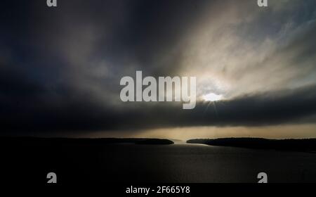 Schwerer, schwarzer Himmel und Meer mit Sonnenuntergang hinter Wolken, im Stockholmer Archipel, Ostsee, Schweden. Stockfoto