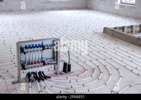 Fußbodenheizung - Wasserleitungen mit Kollektor auf der Neuer Gebäudefußboden Stockfoto