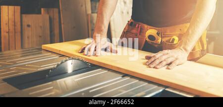 Holzbrett auf einer Tischsäge schneiden. Holzbearbeitung und Zimmerei. Möbelherstellung Stockfoto