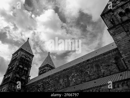 Die südöstliche Erhebung der Kathedrale von Lund, Lund, Schweden, von der Seite, vor dem Hintergrund dramatischer Wolken. S/W Stockfoto