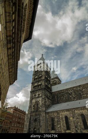 Die Türme der Kathedrale von Lund, Lund, Schweden, von der Seite, vor einem Hintergrund von Wolken und blauem Himmel. Stockfoto