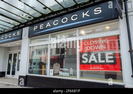 Llandudno, UK: Mar 18, 2021: Peacocks haben ein Mode- und Bekleidungsgeschäft in der Mostyn Street. Ein Fenster Anzeige wirbt ihre Schließung Verkauf. Stockfoto