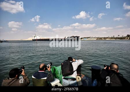 Ismailia, Ägypten. März 2021, 30th. Fotografen fotografieren Schiffe, die durch den Suezkanal segeln, während der Verkehr wieder aufgenommen wird, nachdem das von der Evergreen Marine Corporation betriebene "jemals gegebene" Containerschiff nach einer Blockade der Wasserstraße für fast eine Woche freigelassen wurde. Kredit: Sayed Hassan/dpa/Alamy Live Nachrichten Stockfoto