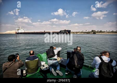 Ismailia, Ägypten. März 2021, 30th. Fotografen fotografieren Schiffe, die durch den Suezkanal segeln, während der Verkehr wieder aufgenommen wird, nachdem das von der Evergreen Marine Corporation betriebene "jemals gegebene" Containerschiff nach einer Blockade der Wasserstraße für fast eine Woche freigelassen wurde. Kredit: Sayed Hassan/dpa/Alamy Live Nachrichten Stockfoto