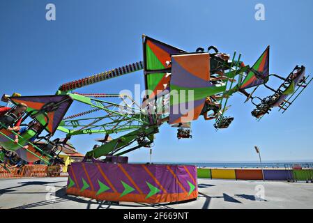 Bei der farbenfrohen Cliff Hanger Fahrt im Santa Cruz Amusement Park in Kalifornien, USA, haben Sie einen malerischen Blick auf die Menschen. Stockfoto