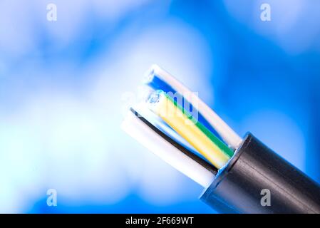 Elektrokabel ohne Isolierung, auf blauem Hintergrund mit Platz für Text. Stockfoto