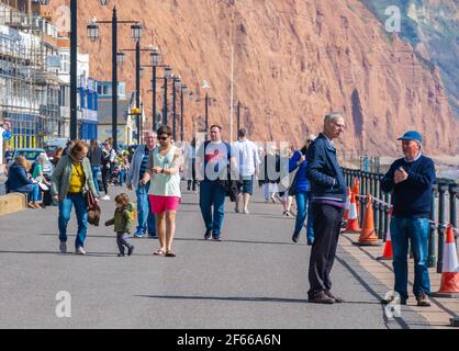 Sidmouth, Devon, Großbritannien. März 2021, 30th. Wetter in Großbritannien: Die Menschen strömen in den Badeort Sidmouth, Devon, um die herrliche Sonne zu genießen, während die Südküste vor dem Osterfeiertagswochenende in einer Mini-März-Hitzewelle sonnt. Man sah die Leute an diesem Nachmittag entlang der hübschen Esplanade spazieren gehen und die heiße Sonne im hübschen Regency Resort genießen. Kredit: Celia McMahon/Alamy Live Nachrichten Stockfoto
