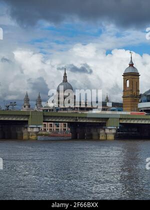 Eine Skyline vom South Bank, die die Cannon Street Bridge mit einem Zug zum Ziel zeigt und die Kuppel der St. Paul's Cathedral im Hintergrund. Stockfoto