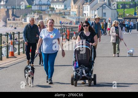 Sidmouth, Devon, Großbritannien. März 2021, 30th. Wetter in Großbritannien: Man sah die Menschen, wie sie Hunde gingen und entlang der hübschen Esplanade in Sidmouth bummelten, um die heiße Sonne am heißesten Tag des Jahres zu genießen. Kredit: Celia McMahon/Alamy Live Nachrichten Stockfoto