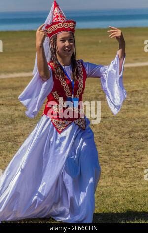 SONG KOL, KIRGISISTAN - 25. JULI 2018: Traditionelles Kleid trägt Mädchen während der National Horse Games Festival am Ufer des Son Kol See Stockfoto