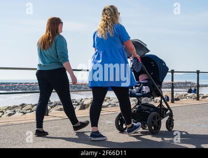 Sidmouth, Devon, Großbritannien. März 2021, 30th. Wetter in Großbritannien: Die Menschen strömen in den Badeort Sidmouth, Devon, um die herrliche Sonne zu genießen, während die Südküste vor dem Osterfeiertagswochenende in einer Mini-März-Hitzewelle sonnt. Man sah die Leute an diesem Nachmittag entlang der hübschen Esplanade spazieren gehen und die heiße Sonne im hübschen Regency Resort genießen. Kredit: Celia McMahon/Alamy Live Nachrichten Stockfoto