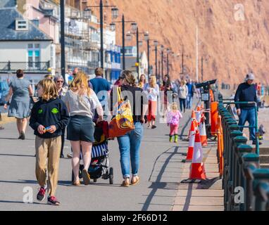 Sidmouth, Devon, Großbritannien. März 2021, 30th. Wetter in Großbritannien: Die Menschen strömen in den Badeort Sidmouth, Devon, um die herrliche Sonne zu genießen, während die Südküste vor dem Osterfeiertagswochenende in einer Mini-März-Hitzewelle sonnt. Man sah die Leute an diesem Nachmittag entlang der hübschen Esplanade spazieren gehen und die heiße Sonne im hübschen Regency Resort genießen. Kredit: Celia McMahon/Alamy Live Nachrichten Stockfoto