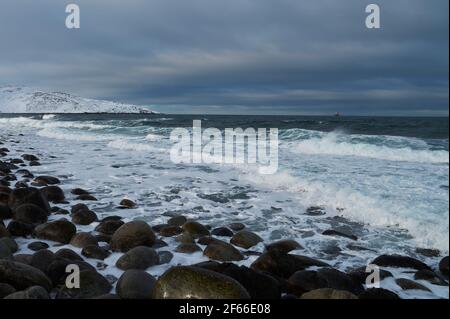Kräftige Wellen brechen an einem steinigen Strand Stockfoto