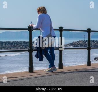 Sidmouth, Devon, Großbritannien. März 2021, 30th. Wetter in Großbritannien: Die Menschen strömen in den Badeort Sidmouth, Devon, um die herrliche Sonne zu genießen, während die Südküste vor dem Osterfeiertagswochenende in einer Mini-März-Hitzewelle sonnt. Man sah die Leute an diesem Nachmittag entlang der hübschen Esplanade spazieren gehen und die heiße Sonne im hübschen Regency Resort genießen. Kredit: Celia McMahon/Alamy Live Nachrichten Stockfoto