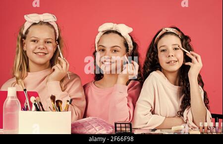 Entspannen und Spaß haben. Kleine Mädchen in Schönheitssalon. Kleine Schwestern in Retro-Mode Kopftuch. Make-up für Kinder. Gruppe von glücklichen Freunden im Spa Stockfoto