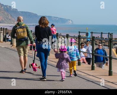 Sidmouth, Devon, Großbritannien. März 2021, 30th. Wetter in Großbritannien: Die Menschen strömen in den Badeort Sidmouth, Devon, um die herrliche Sonne zu genießen, während die Südküste vor dem Osterfeiertagswochenende in einer Mini-März-Hitzewelle sonnt. Man sah die Leute an diesem Nachmittag entlang der hübschen Esplanade spazieren gehen und die heiße Sonne im hübschen Regency Resort genießen. Kredit: Celia McMahon/Alamy Live Nachrichten Stockfoto