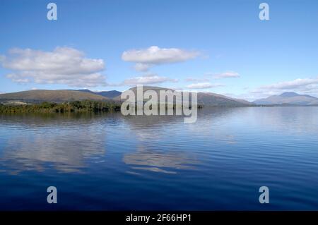 Weitwinkel, Panoramablick auf das unberührte Wasser von Loch Lomond mit den Bergen der schottischen Highlands im Hintergrund. Stockfoto