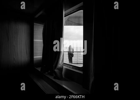 Eine Fähre mit einem Passagier am Morgen, schwarz und weiß Stockfoto