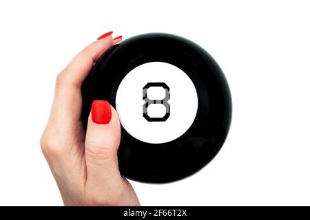 Magic 8 Ball von Vorhersagen in weiblicher Hand mit rot Nägel auf weißem Hintergrund isoliert Stockfoto