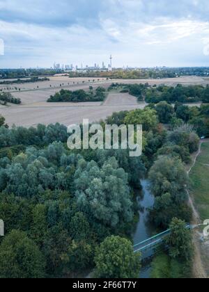 Blick auf die frankfurter Skyline aus der Luft. Mit Feldern und Fluss Nidda im Vordergrund bei hellem Tageslicht. Stockfoto