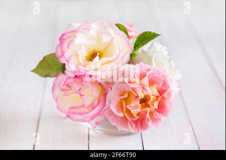 Kleiner Strauß Rosen auf einem schäbigen Holztisch. Selektiver Fokus. Stockfoto