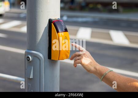 Frau Hand drücken Crosswalk-Taste, um die Straße zu überqueren. Sichere Straßenüberquerung. Gehen Sie nicht laufen Signal in der Stadt Stockfoto