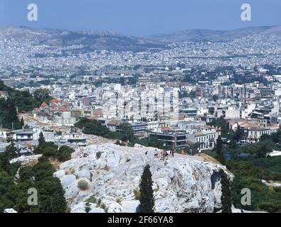 Griechenland, Athen, Blick von der Akropolis, mit Touristen, die den felsigen Berg erklimmen Stockfoto