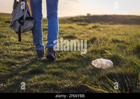 Verschmutzung der Umwelt durch Plastik. Wanderer weg von der Plastikflasche im Gras. Verantwortungslose Menschen und Umweltschutz Stockfoto