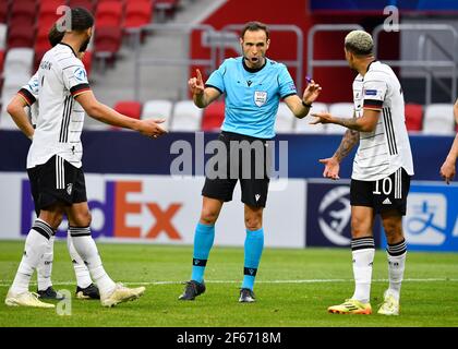 Budapest, Ungarn. März 2021, 30th. Fußball, U-21 Männer: Europameisterschaft, Deutschland - Rumänien, Vorrunde, Gruppe A, Matchday 3, Bozsik Arena. Schiedsrichter Guillermo Cuadra Fernandez aus Spanien spricht mit dem deutschen Lukas Nmecha (r). Kredit: Marton Monus/dpa/Alamy Live Nachrichten Stockfoto