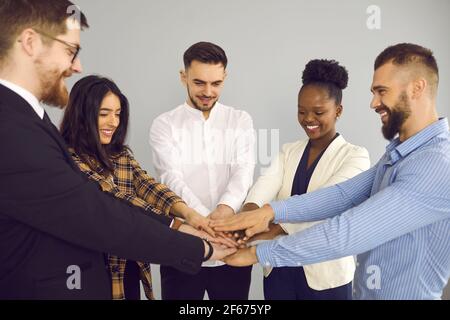 Gruppe von glücklichen Geschäftsleuten demonstrieren Teamarbeit und setzen ihre Hände zusammen Stockfoto