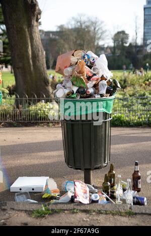 Leamington Spa, Warwickshire, Großbritannien, 30th. März 2021: Die Mülltonnen werden bis zum Rand mit Flaschen und Dosen und Lebensmittelabfällen gefüllt, während Hunderte auf die Felder rund um den Victoria Park in Leamington strömen, darunter viele Studenten der nahe gelegenen Warwick University. Kredit: Ryan Underwood / Alamy Live Nachrichten Stockfoto