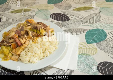 Hausgemachte 'Feijoada' bereit zu essen. Es ist ein typisch portugiesisches Gericht aus gekochten weißen Bohnen, Gemüse, Rindfleisch und Schweinefleisch mit Reis serviert. Stockfoto