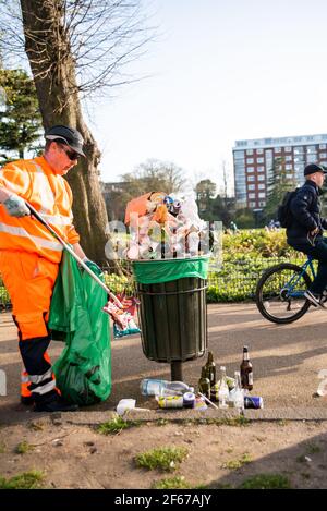 Leamington Spa, Warwickshire, Großbritannien, 30th. März 2021: Die Mülltonnen werden bis zum Rand mit Flaschen und Dosen und Lebensmittelabfällen gefüllt, während Hunderte auf die Felder rund um den Victoria Park in Leamington strömen, darunter viele Studenten der nahe gelegenen Warwick University. Kredit: Ryan Underwood / Alamy Live Nachrichten Stockfoto