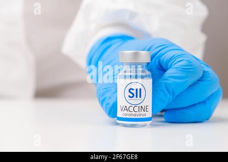 Serum Institute of India SII-Impfstoff gegen SARS-Cov-2, Coronavirus oder Covid-19, vom Arzt in Gummihandschuhen auf den Tisch gelegt, März 2021 Stockfoto