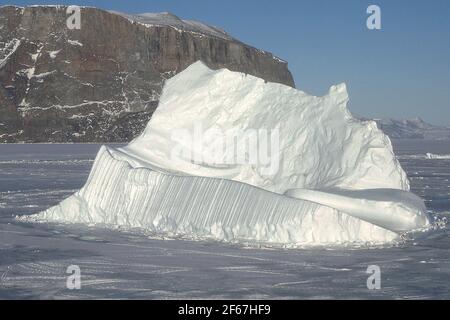 EISBERG IM GEFRORENEN MEER BEI UUMMANNAQ, GRÖNLAND. Stockfoto