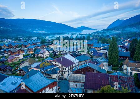 Drohnenansicht der Stadt im Bergtal. Nebliger Morgen zwischen den Graten. Schönheit der Giffre-Bergregion, Frankreich. Stockfoto