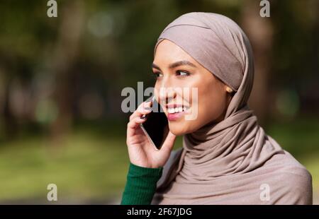 Happy Muslim Frau Sprechen Am Telefon Anrufen Freund Stehen Im Freien Stockfoto