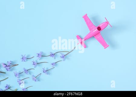 Rosa Flugzeug nimmt in eine scharfe Wendung auf blauem Hintergrund Stockfoto