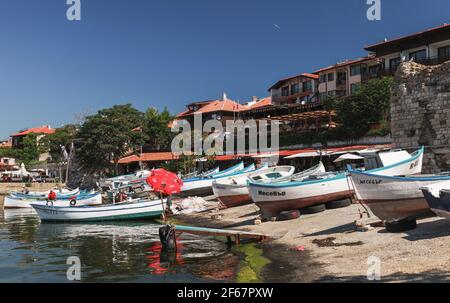 Nessebar, Bulgarien - 21. Juli 2014: Hölzerne Fischerboote lagen am Hang in der Altstadt von Nessebar, Schwarzmeerküste. Die Leute sind auf der Straße Stockfoto