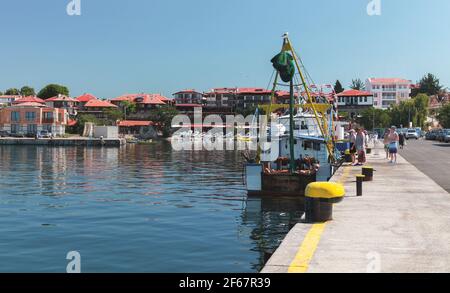 Nessebar, Bulgarien - 21. Juli 2014: Touristen kaufen Fisch auf einem Fischerboot im Hafen von Nessebar Stockfoto