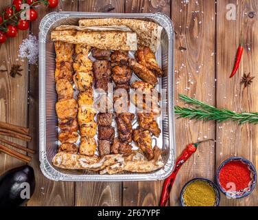 Shish Kebab und lula Kebab werden in einen Behälter gegeben. Lieferung von Lebensmitteln aus Restaurants. Stockfoto