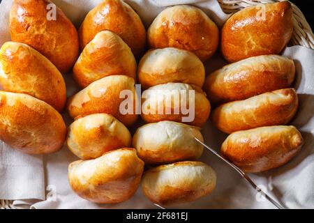 Frisch gebackene Kuchen liegen auf einem Tablett Draufsicht. Pinzette für Brötchen. Stockfoto