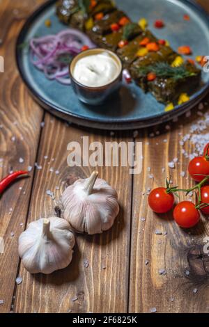 Knoblauch, Kirschtomaten, Chilischoten und andere Gerichte auf braunem Holzhintergrund. Stockfoto