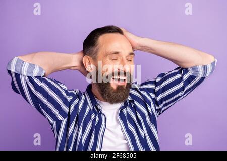 Foto von positiven reifen Mann berühren Hände Kopf seidig Shampoo Haarwaschkonzept isoliert über violettem Hintergrund Stockfoto